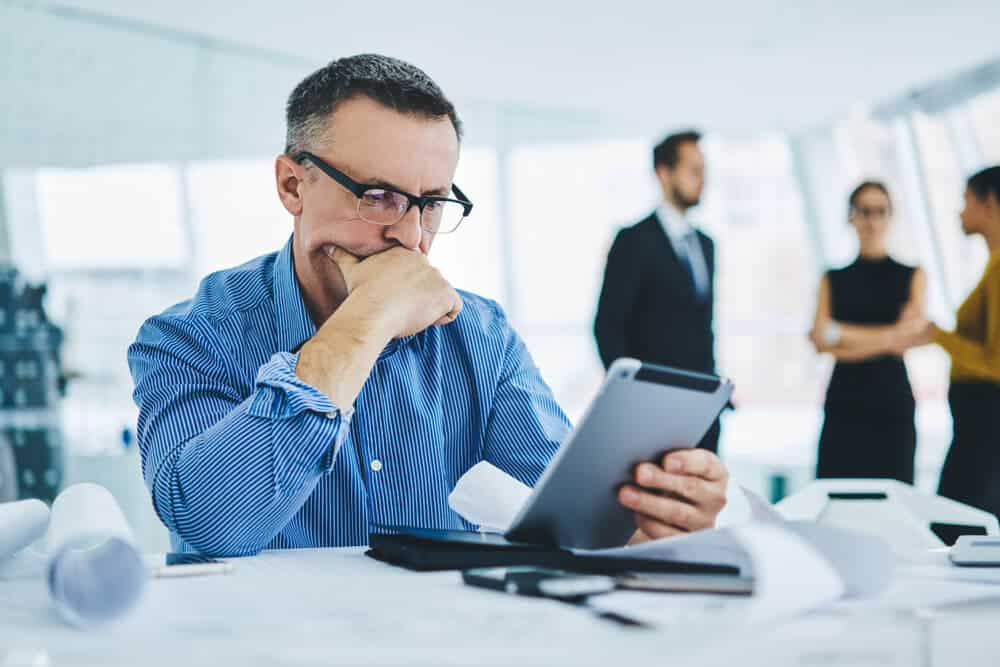 profissional serio lendo ebook em ambiente de trab